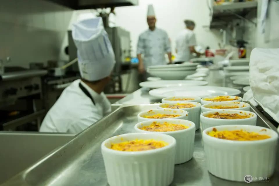 Chefs plating dishes on a restaurant kitchen line